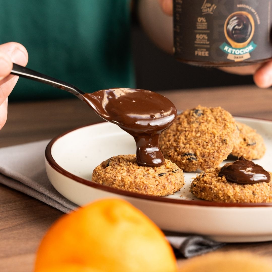 Cucchiaio di Ketociok Dark sopra biscotti in un piatto, a colazione