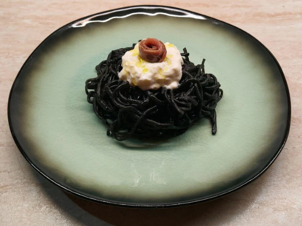 Spaghetti with squid ink, anchovies and stracciatella cheese